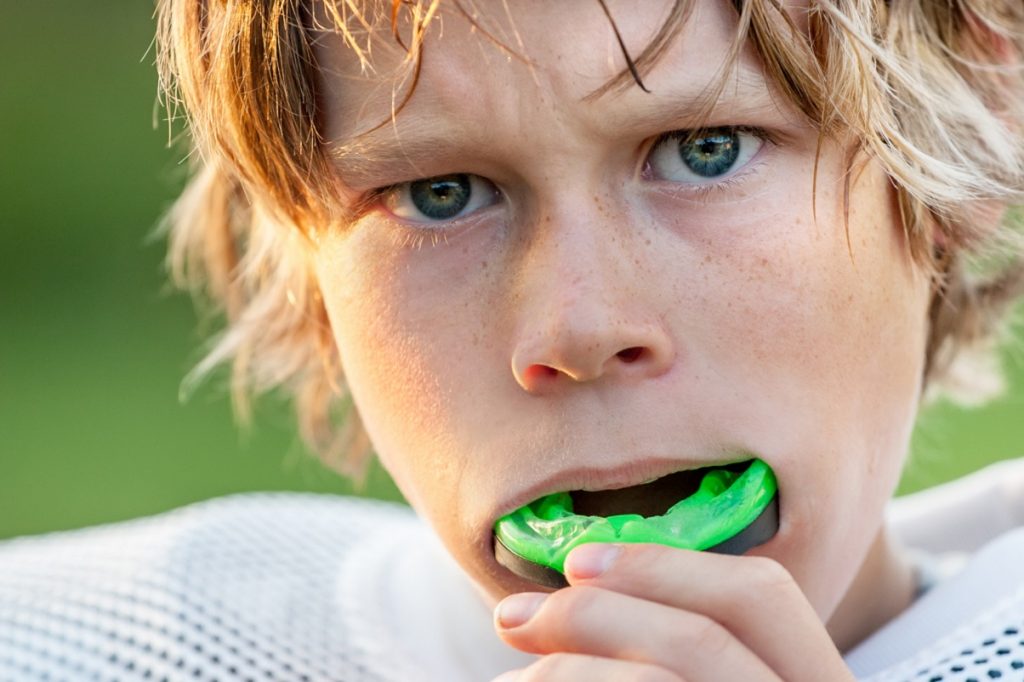 Young athlete about to use his mouth guard